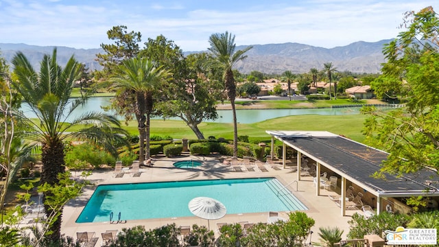 view of swimming pool with a patio, a water and mountain view, and a yard