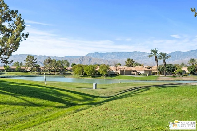 surrounding community featuring a water and mountain view and a yard