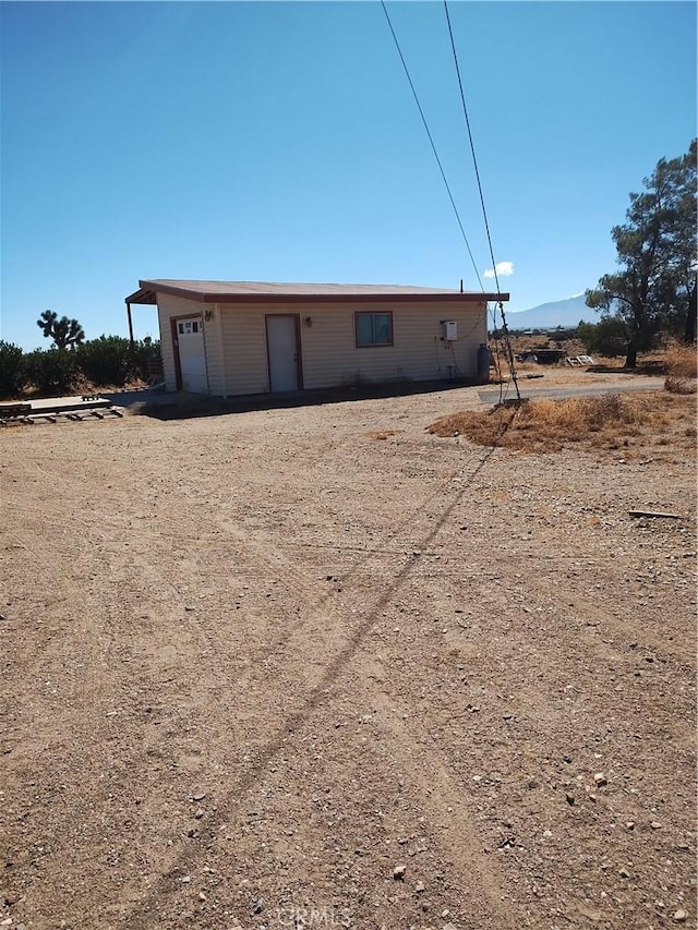 view of front of property with a mountain view, an outbuilding, and a garage