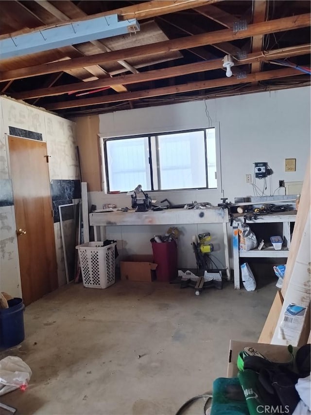 miscellaneous room featuring a workshop area and concrete flooring