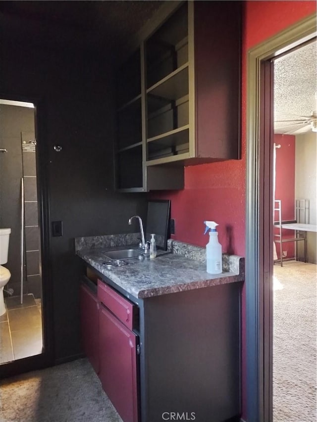 kitchen with carpet flooring, a textured ceiling, ceiling fan, and sink