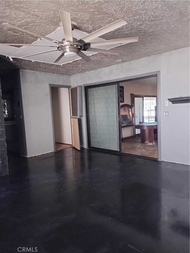 interior space with concrete flooring, a textured ceiling, and ceiling fan