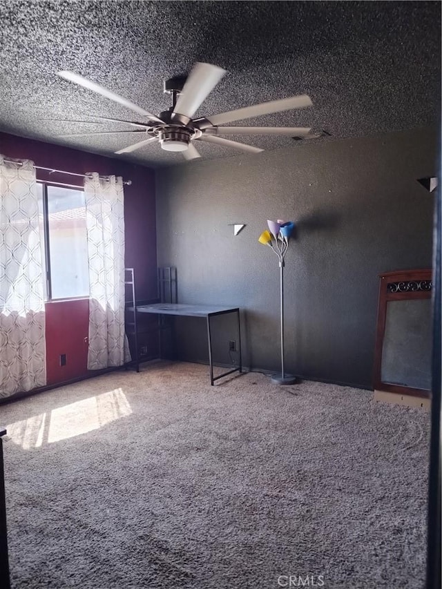 unfurnished room with ceiling fan, carpet floors, and a textured ceiling