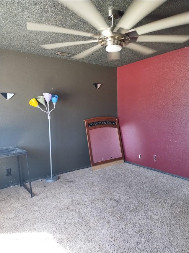 spare room featuring carpet, a textured ceiling, and ceiling fan