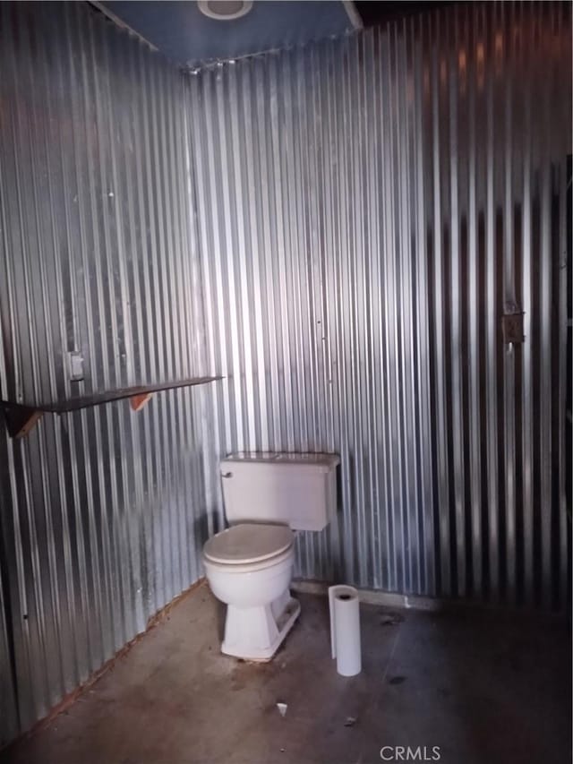 bathroom featuring concrete flooring and toilet