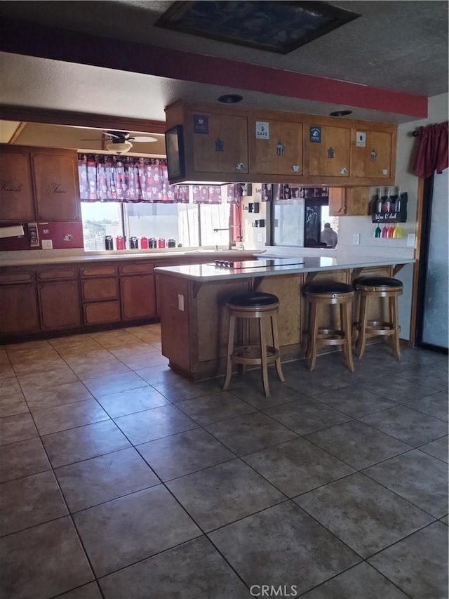 kitchen with a breakfast bar, dark tile patterned floors, and kitchen peninsula