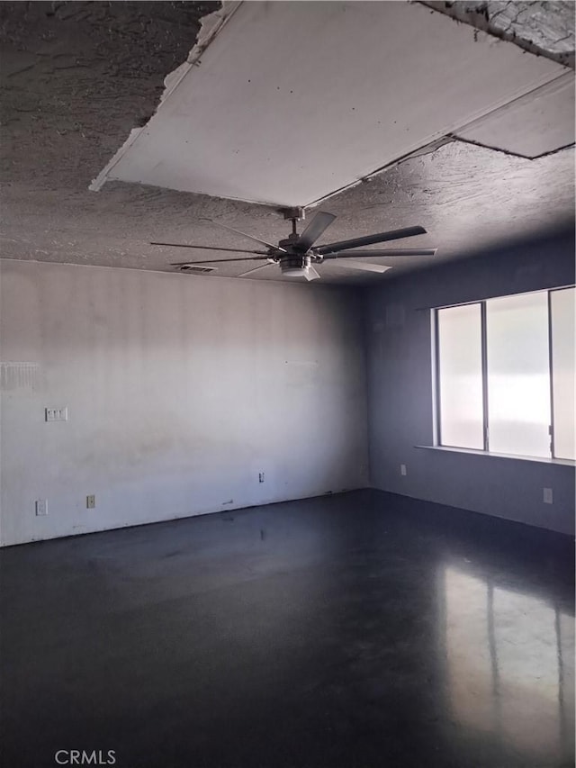 spare room featuring ceiling fan and concrete flooring