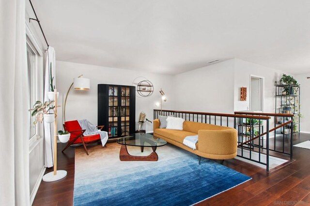 living room with dark hardwood / wood-style floors and an inviting chandelier