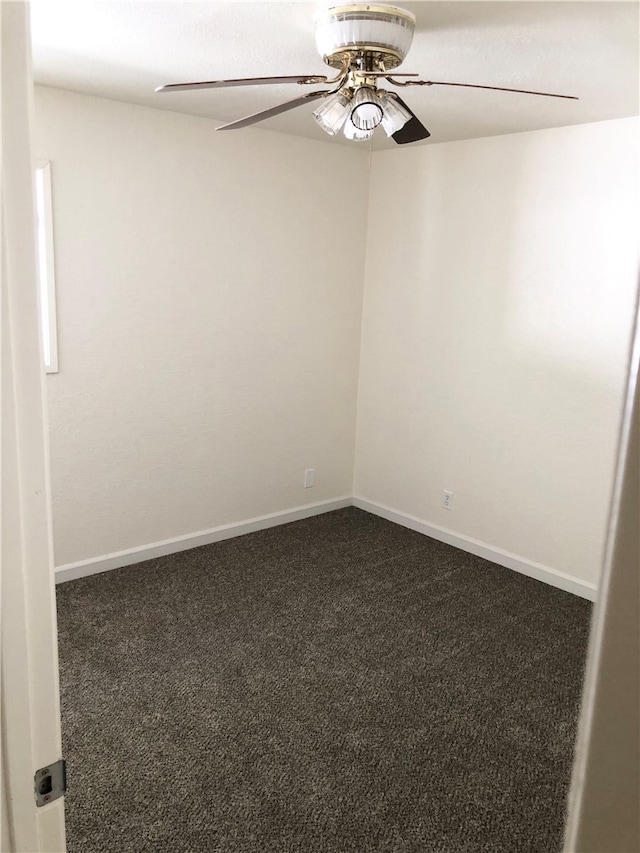 empty room featuring dark carpet and ceiling fan