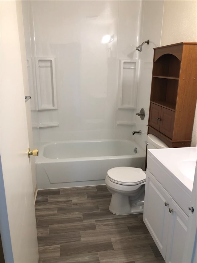 full bathroom featuring hardwood / wood-style flooring, shower / washtub combination, vanity, and toilet