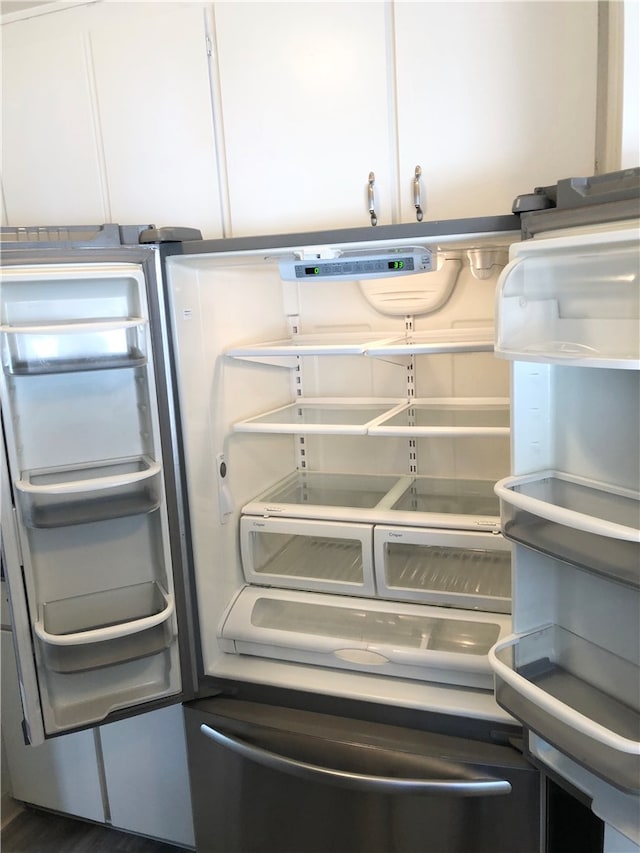 room details featuring refrigerator with ice dispenser and white cabinets