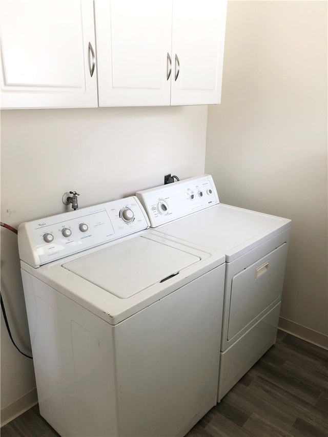 laundry room featuring dark hardwood / wood-style floors, independent washer and dryer, and cabinets