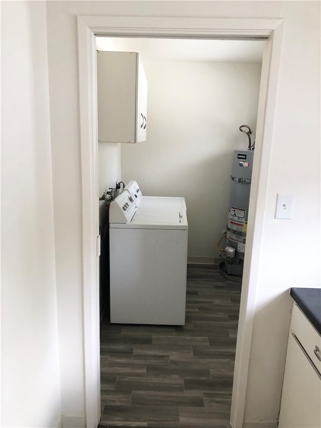 clothes washing area featuring cabinets, dark wood-type flooring, independent washer and dryer, and secured water heater