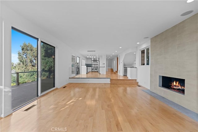 unfurnished living room featuring a fireplace and light hardwood / wood-style floors