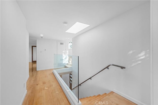 stairs featuring hardwood / wood-style flooring and a skylight