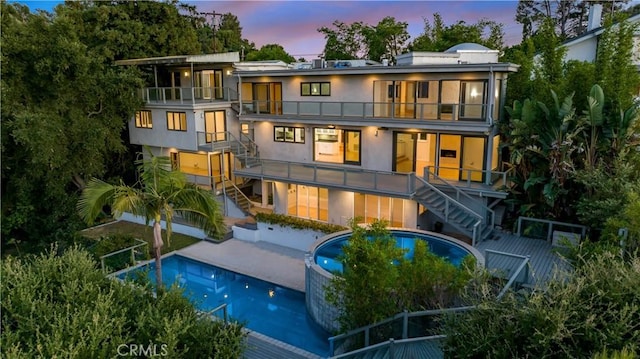 back house at dusk with a balcony