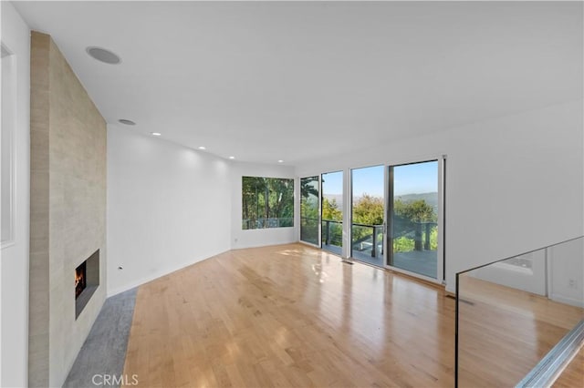 unfurnished living room with a fireplace and light hardwood / wood-style flooring