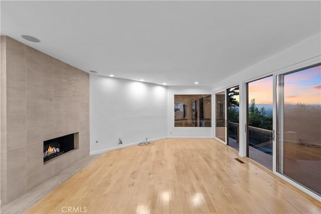 unfurnished living room featuring wood-type flooring and a fireplace