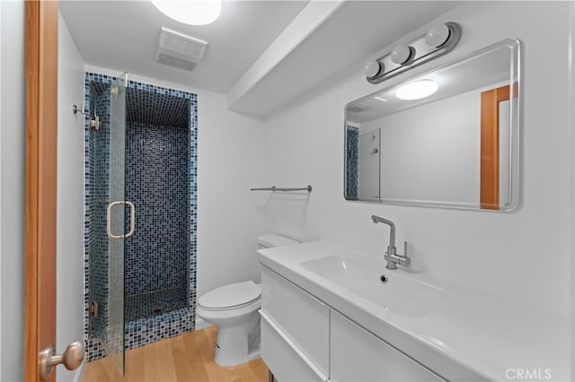 bathroom with a shower with door, wood-type flooring, vanity, and toilet