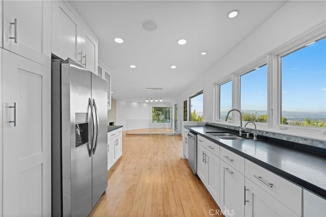 kitchen featuring sink, plenty of natural light, stainless steel appliances, and white cabinets