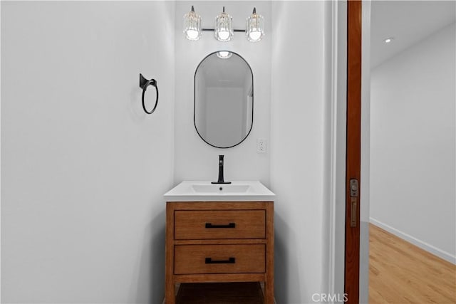 bathroom featuring baseboards, wood finished floors, and vanity