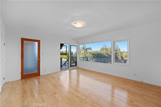 spare room featuring baseboards and light wood-type flooring