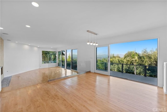 spare room with plenty of natural light, wood finished floors, and recessed lighting