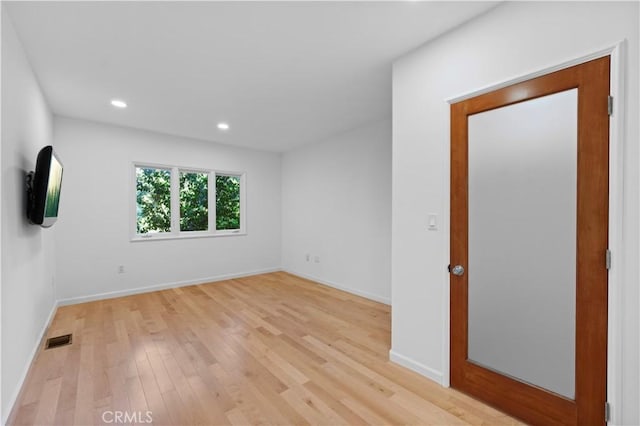 unfurnished room featuring light wood finished floors, visible vents, recessed lighting, and baseboards