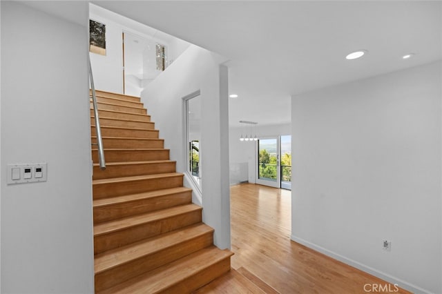 stairway with recessed lighting, baseboards, and wood finished floors