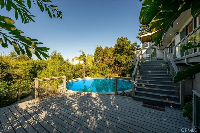 pool featuring a wooden deck and stairs