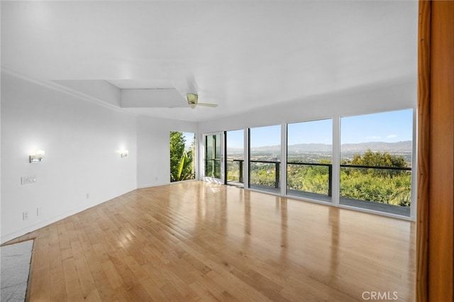 interior space with a mountain view, a ceiling fan, and hardwood / wood-style floors