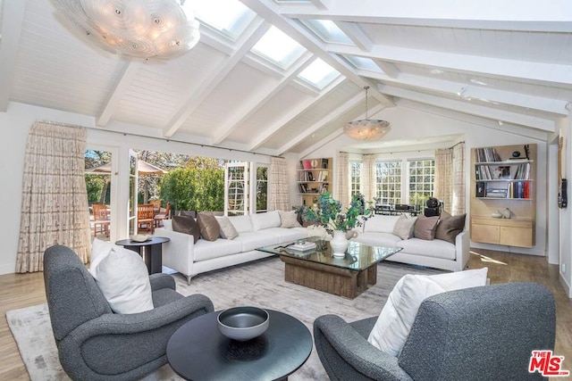 sunroom / solarium featuring vaulted ceiling with skylight