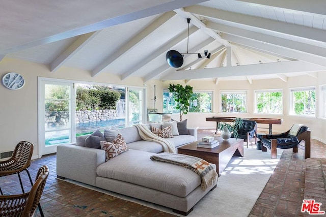 living room featuring a healthy amount of sunlight and lofted ceiling with beams