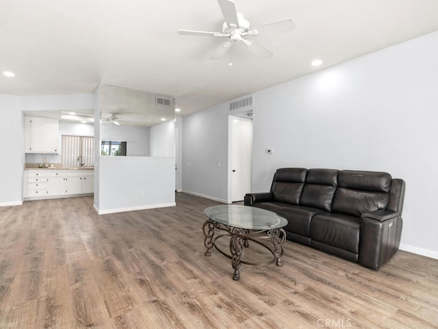 living room featuring light hardwood / wood-style floors and ceiling fan