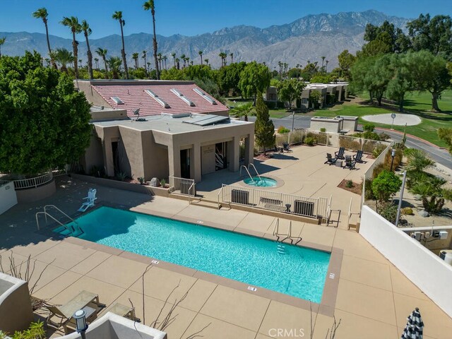 view of swimming pool with a mountain view and a patio area