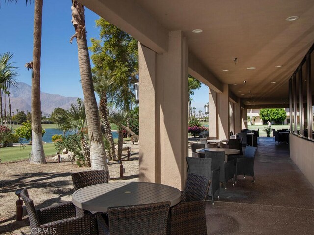 view of patio / terrace featuring a water and mountain view