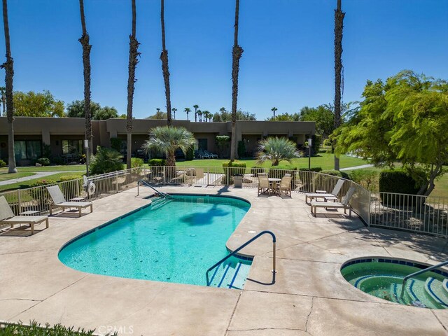 view of pool with a yard, a patio area, and a hot tub