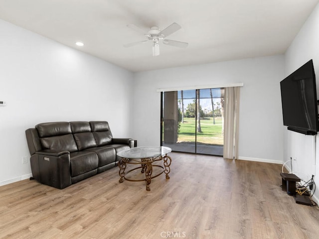 living room featuring light hardwood / wood-style flooring and ceiling fan