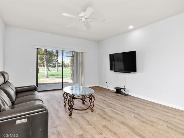 living room featuring light wood-type flooring and ceiling fan