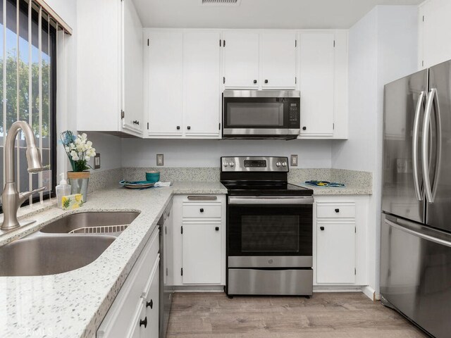 kitchen featuring light hardwood / wood-style flooring, stainless steel appliances, white cabinetry, and sink