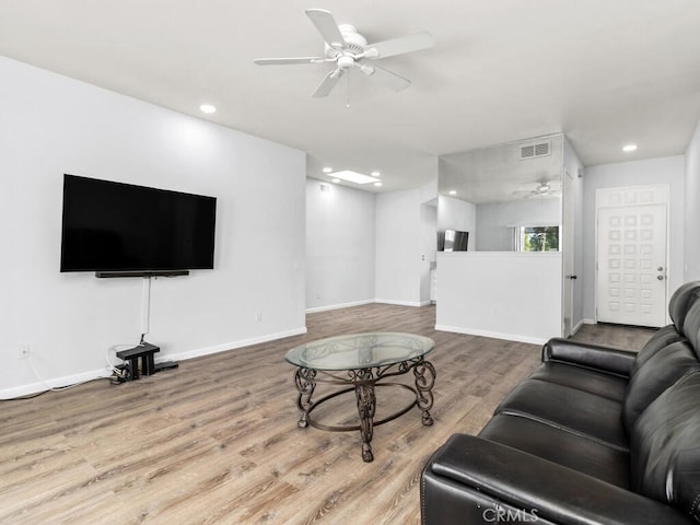 living room featuring hardwood / wood-style floors and ceiling fan