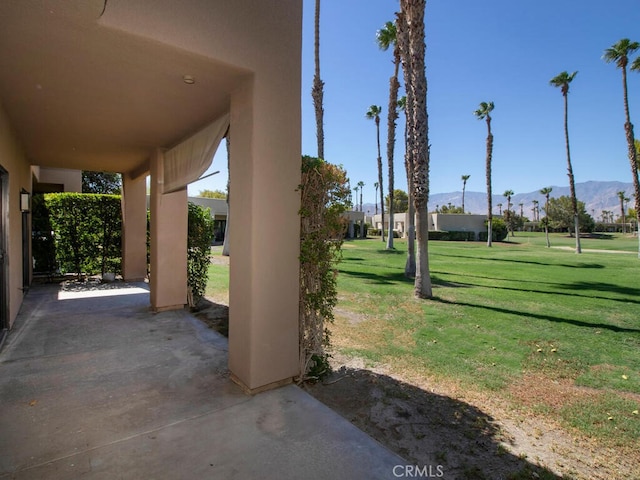 exterior space with a mountain view, a lawn, and a patio area