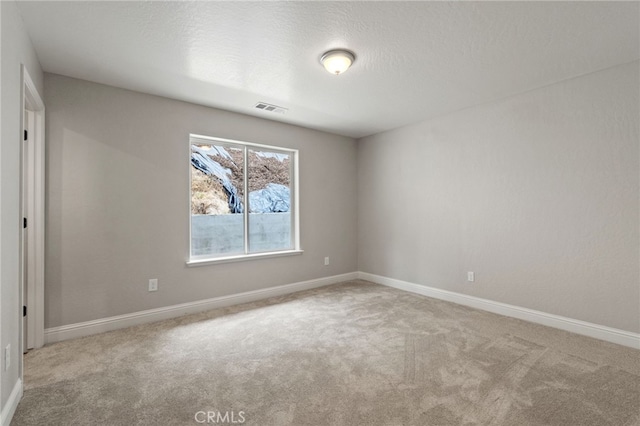 carpeted spare room with a textured ceiling