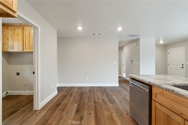 kitchen featuring wood-type flooring, dishwasher, and light stone countertops