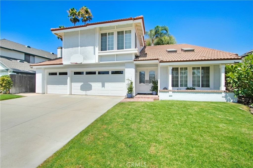 mediterranean / spanish house featuring a garage and a front yard