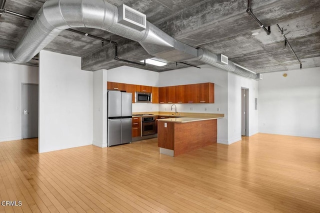 kitchen with sink, light hardwood / wood-style flooring, a center island, and appliances with stainless steel finishes