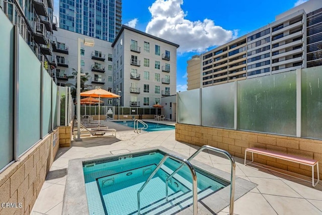 view of pool featuring a patio area and a hot tub