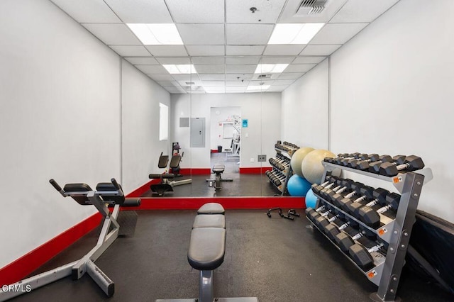 exercise room featuring a drop ceiling and electric panel