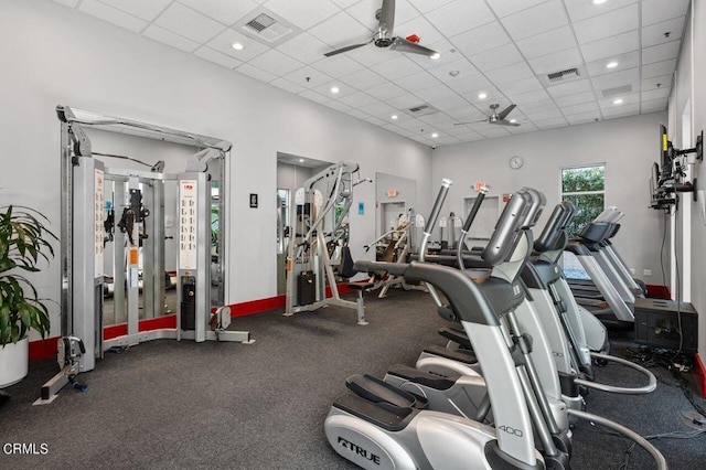 gym with a paneled ceiling and ceiling fan