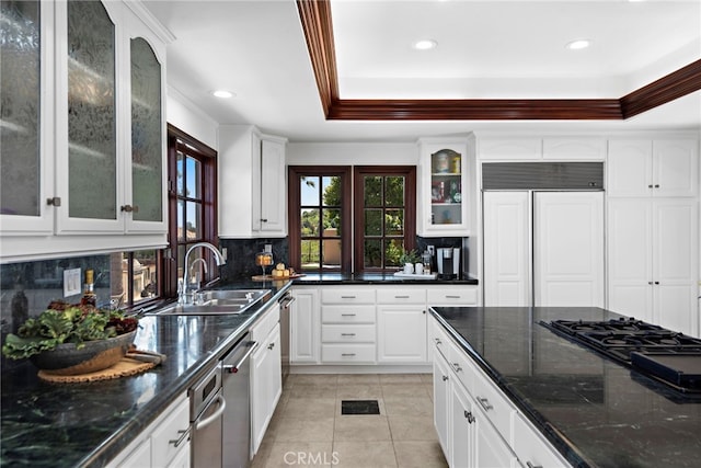 kitchen with white cabinets, tasteful backsplash, a tray ceiling, sink, and paneled fridge